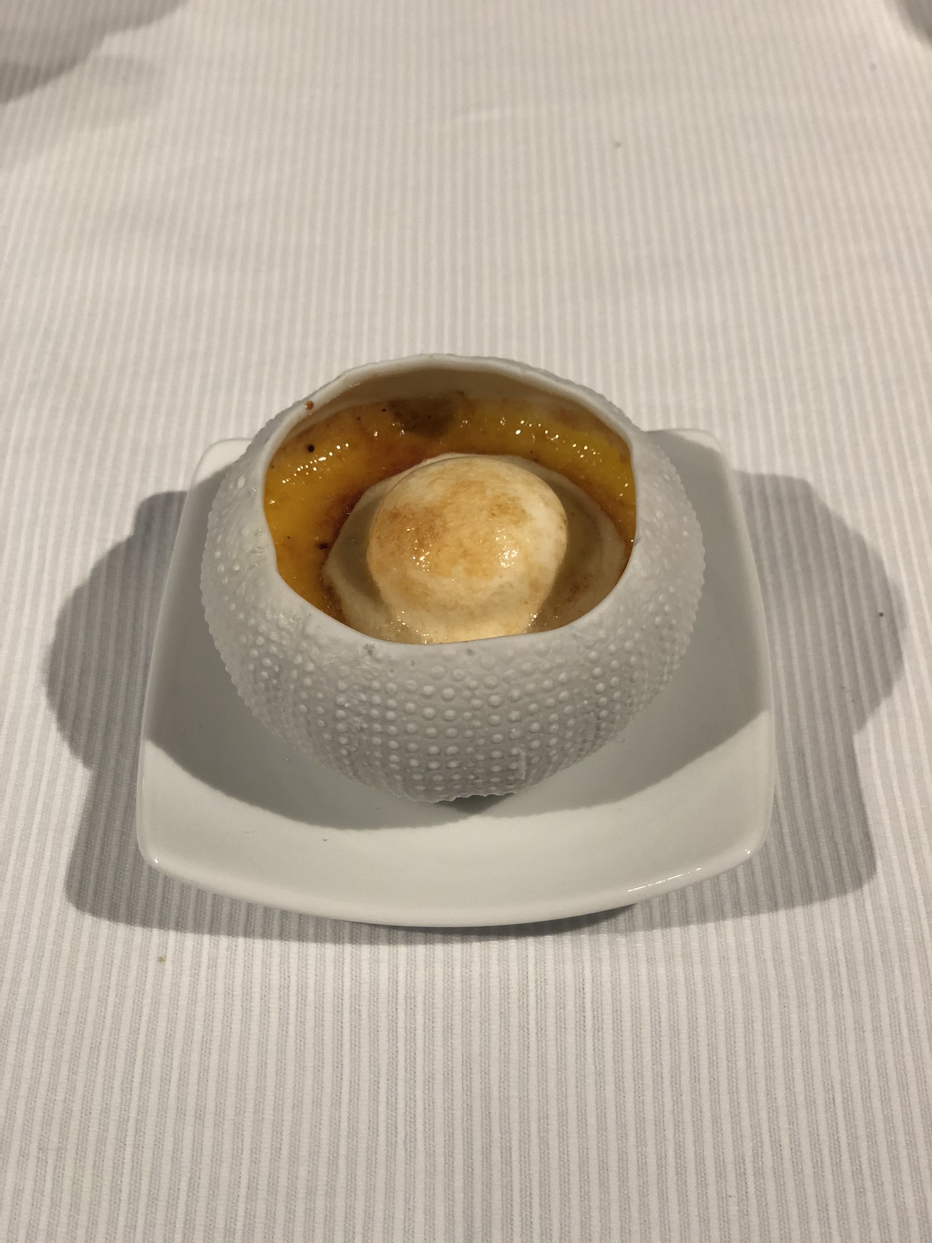 Creme brulee dessert in a sea urchin ceramic bowl